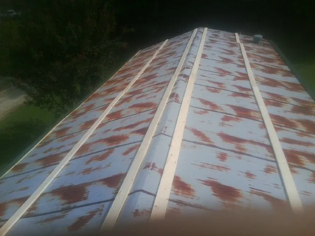 Rusted metal roof panels with new wood purlins before replacement — Storm Damage Roof Repair in Crescent Mills by Roofing Brothers