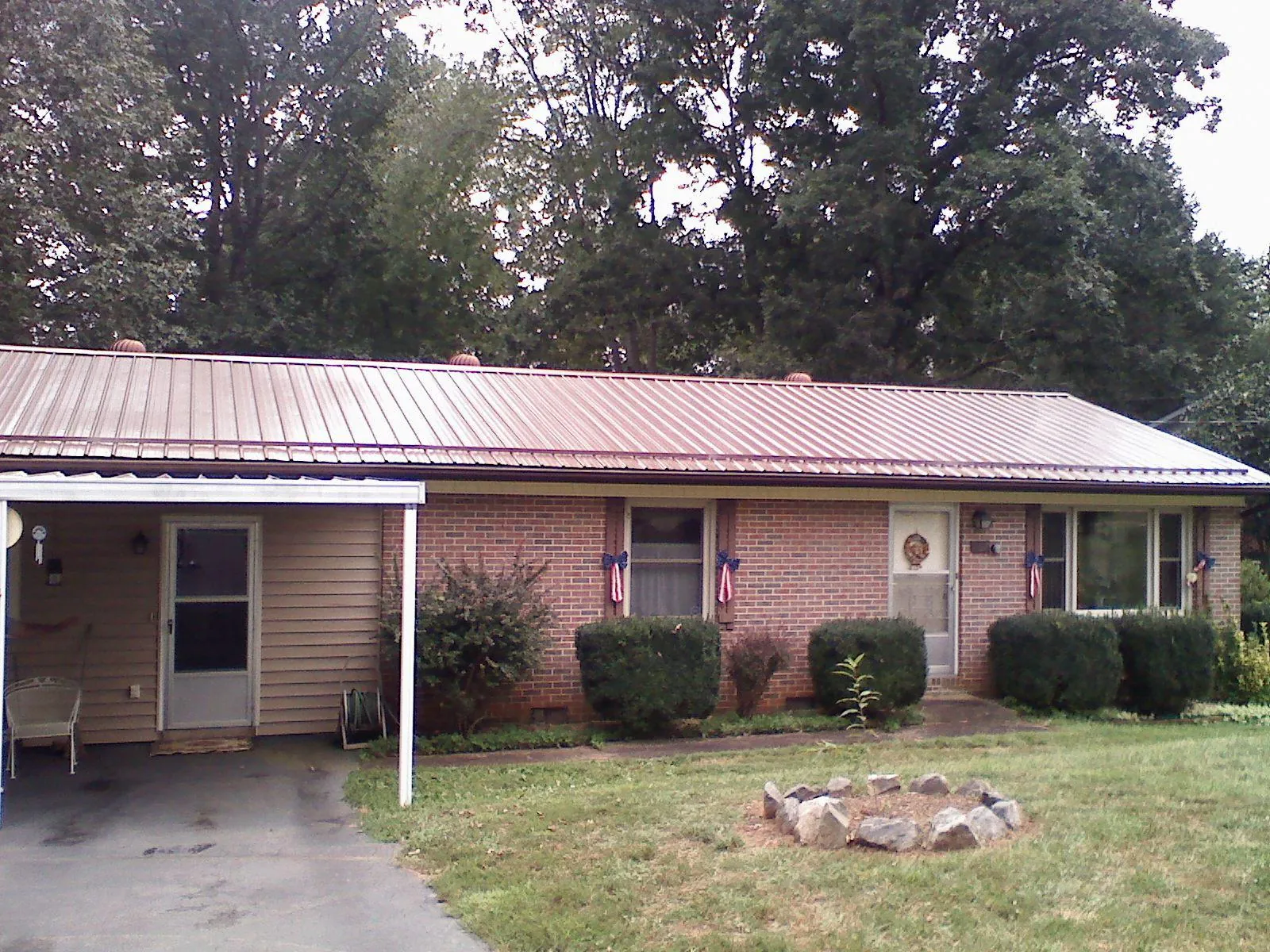 Bronze metal roof and carport on a brick ranch home — Roof Repair work by our crew in Crescent Mills